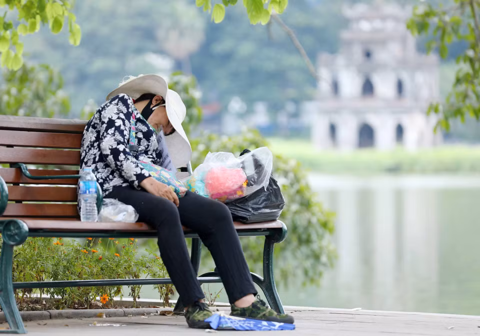 Một người bán hàng mệt mỏi trong thời tiết nắng nóng trưa 28/6/2022. (Ảnh: Hoàng Hiếu/TTXVN)