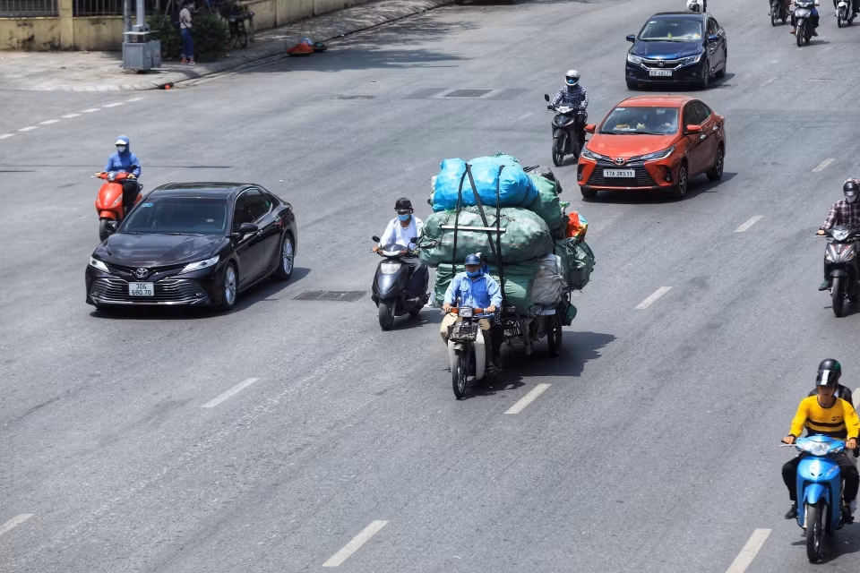 Nắng nóng gây khó khăn vất vả cho nhiều người khi di chuyển ngoài trời. (Ảnh: Tuấn Anh /TTXVN)
