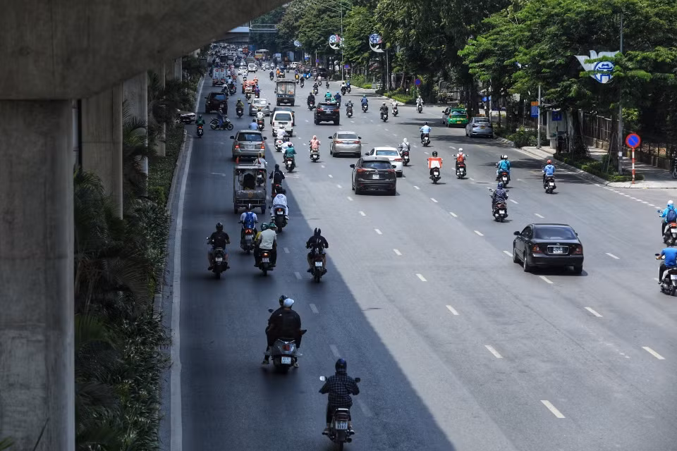 Bóng râm của tuyến đường sắt trên cao trở thành nơi tránh nắng đối với người tham gia giao thông. (Ảnh: Tuấn Anh/TTXVN)