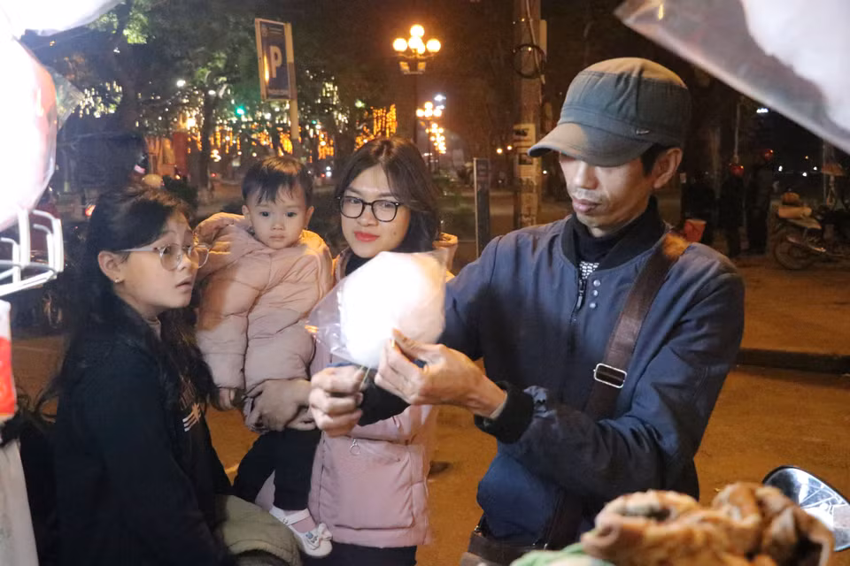 Anh Trương Phú Huyên, bán hàng kẹo kéo tại khu vực công viên Thống Nhất chia sẻ rằng kinh tế phục hồi sau đại dịch giúp việc buôn bán năm nay thuận lợi hơn. (Ảnh: Việt Anh/Vietnam+)