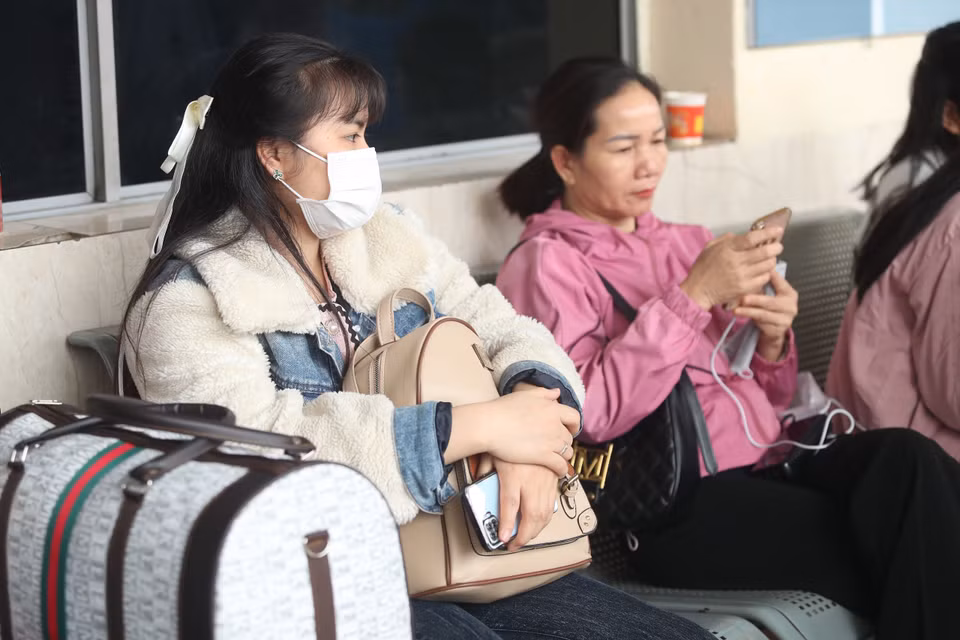 Hành khách tại Bến xe Mỹ Đình 'thảnh thơi' ngồi chờ chuyến xe cuối cùng trong năm. (Ảnh: PV/Vietnam+)