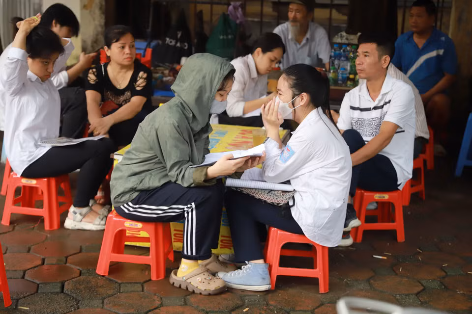 Không ít thí sinh đã đến điểm thi sớm hơn 1 tiếng để ôn lại kiến thức trước khi vào phòng thi. (Ảnh: PV/Vietnam+)