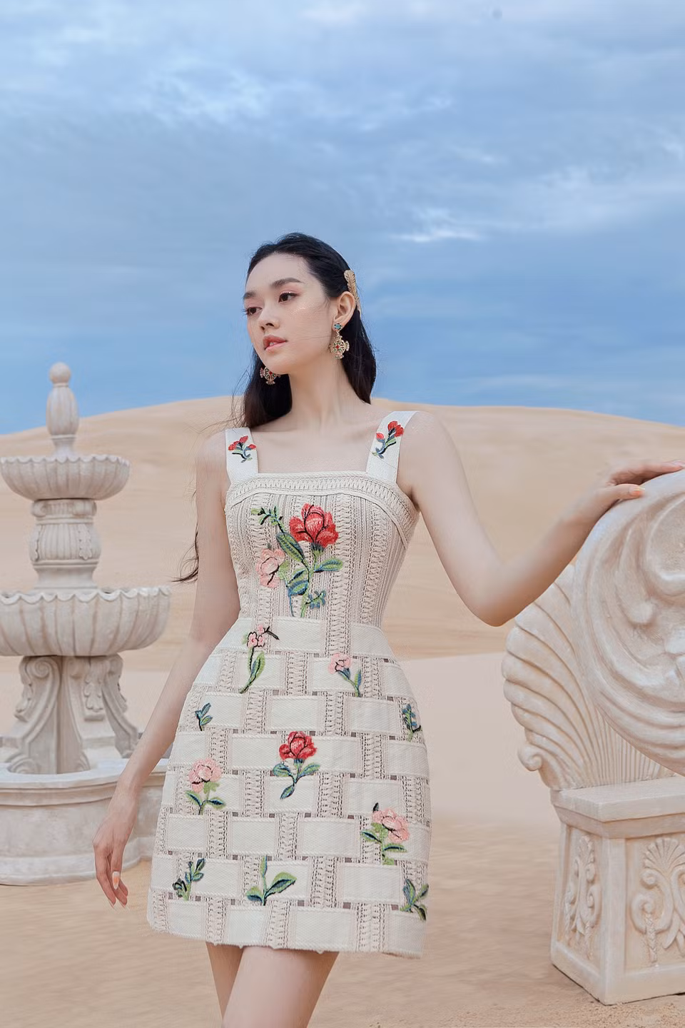 Á hậu cho biết cô gặp không ít khó khăn khi đi giày cao gót đứng trên cát. Tuy nhiên, cô vẫn cố gắng trụ vững, tự tin thả dáng với thần thái quyến rũ, hoàn thành xuất sắc bộ ảnh và thể hiện đúng tinh thần của bộ sưu tập. (Ảnh: CTV/Vietnam+)