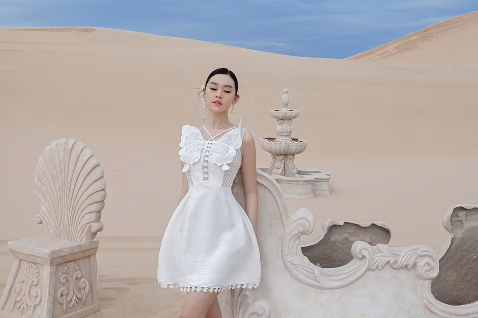 Á hậu 2 Miss World Vietnam 2019 Tường San rạng rỡ tại đồi cát với những thiết kế đầm thanh lịch, tôn làn da trắng nõn nà. (Ảnh: CTV/Vietnam+)