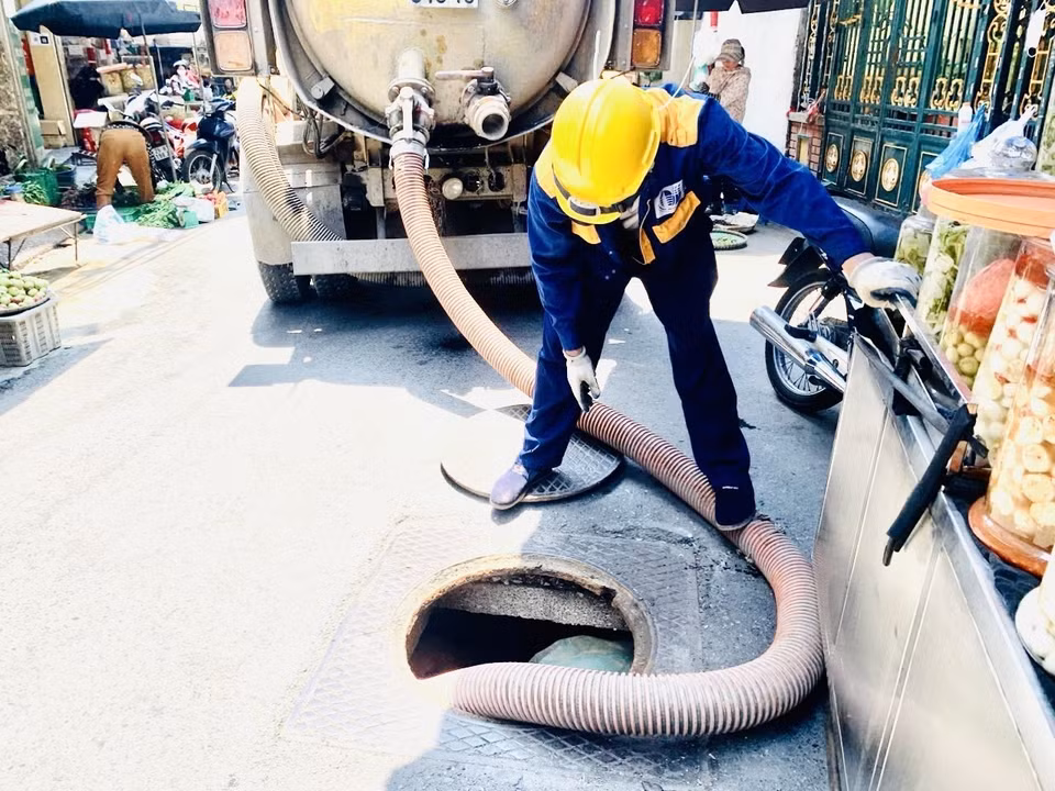 Bất chấp nắng nóng khắc nghiệt, công nhân thoát nước Hà Nội vẫn nạo vét, vệ sinh các miệng xả, hậu cống, ga hàm ếch, ga thu để đảm bảo khả năng tiêu thoát nước. (Ảnh: TTXVN phát)