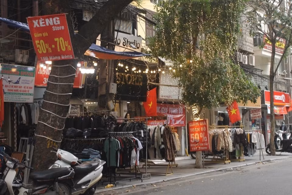 Các cửa hàng quần áo cố gắng giảm giá 'sập sàn' để thu hồi vốn trước khi đóng cửa nghỉ Tết. (Ảnh: Minh Nghĩa/TTXVN)
