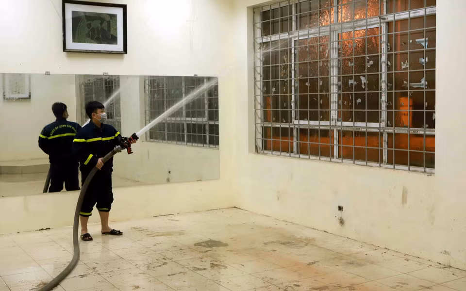 Lính cứu hỏa phun nước vệ sinh các phòng dùng để làm bệnh viện dã chiến. (Ảnh: Hoàng Hùng/TTXVN)