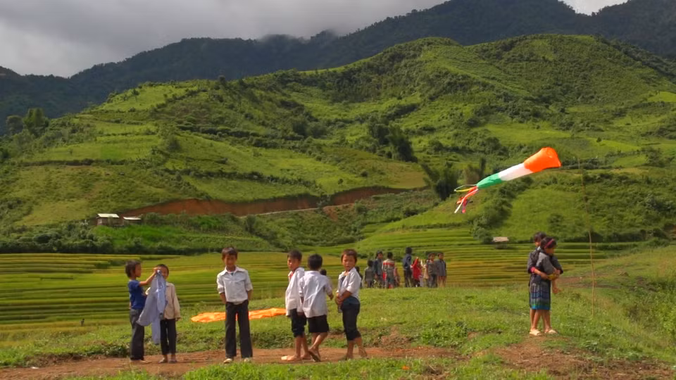 Đội nắng, đội gió và có lúc đội cả mưa nhưng vẫn háo hức chờ một cánh diều bổ bộ. (Ảnh: Tùng Lâm/Vietnam+)