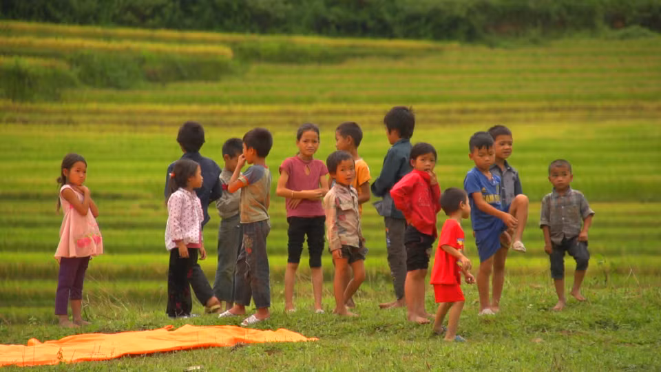 Trẻ em chờ đón phi công ở bãi đáp dưới chân đèo Khau Phạ... (Ảnh: Tùng Lâm/Vietnam+)