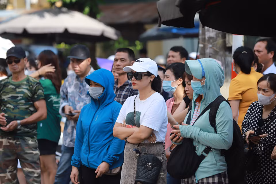 Dù kỳ thi diễn ra vào ngày trong tuần nhưng nhiều bậc phụ huynh vẫn 'túc trực' ngay trước cổng trường tại điểm thi mà con em mình dự thi. (Ảnh: PV/Vietnam+)