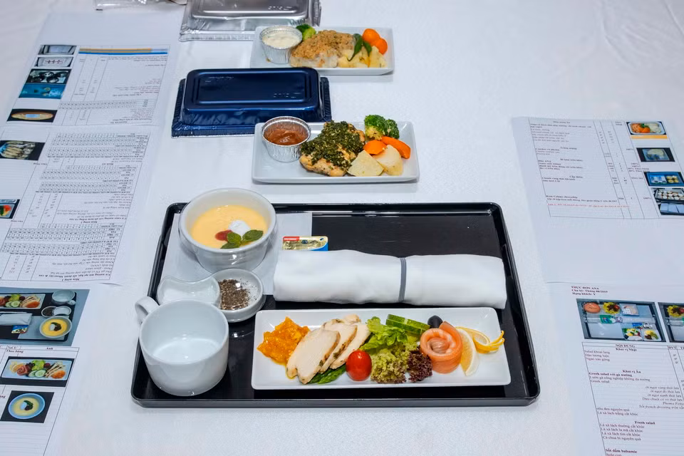 Ở hạng Thương gia món Âu, hành khách sẽ được thưởng thức cá hồi hun khói với lườn gà nướng lá thơm ăn kèm sốt mayonaise cary với mơ cùng một số loại rau củ tươi ngon. Gà được nướng mềm với mù tạt hạt và sốt demi ăn kèm khoai tây và rau. Trong khi đó, cá vược tẩm ướp đậm vị với sốt lá thơm phủ lên trên nướng bỏ lò, ăn kèm với sốt kem trắng. (Ảnh: CTV/Vietnam+)