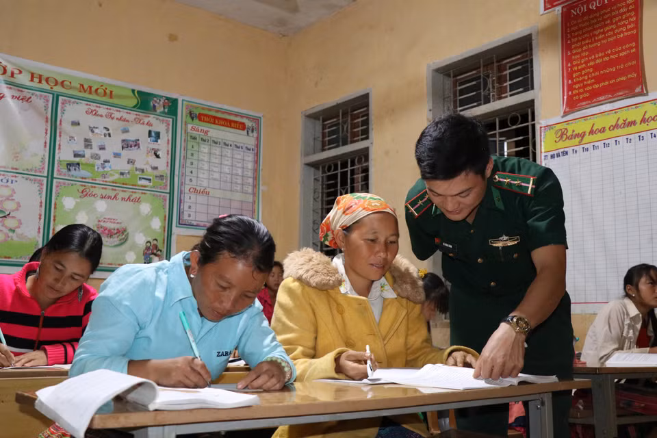 Thầy giáo Vì Văn Liêm, Đồn biên phòng Mường Lạn, hướng dẫn bà con học bài. (Ảnh: Hữu Quyết/TTXVN)