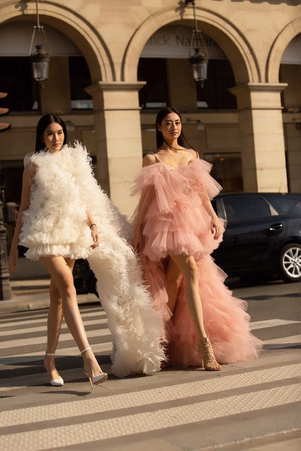 Hai nàng hậu đọ sắc xinh đẹp trên đường phố Paris, nổi bật trong những thiết kế mới nhất được lấy cảm hứng từ vải tuyn, ren Pháp và macramé cùng bảng màu sắc thanh lịch vàng, đen, trắng, hồng, mang đến những bộ trang phục sáng tạo đột phá, độc đáo, không kém phần quyến rũ. (Ảnh: CTV/Vietnam+)