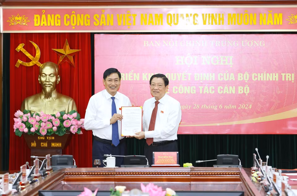 Ông Phan Đình Trạc, Ủy viên Bộ Chính trị, Bí thư Trung ương Đảng, Trưởng Ban Nội chính Trung ương trao Quyết định của Bộ Chính trị cho ông Nguyễn Hữu Đông. (Ảnh: Phương Hoa/TTXVN)