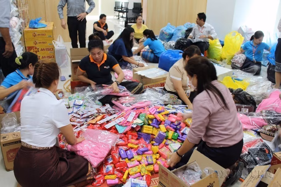 Các doanh nghiệp Việt Nam hợp tác, đầu tư tại Lào chung tay hỗ trợ người dân các bản bị ảnh hưởng bởi sự cố vỡ đập thủy điện Sepien Senamnoy, tại tỉnh Attapeu. (Ảnh: Phạm Kiên/TTXVN)