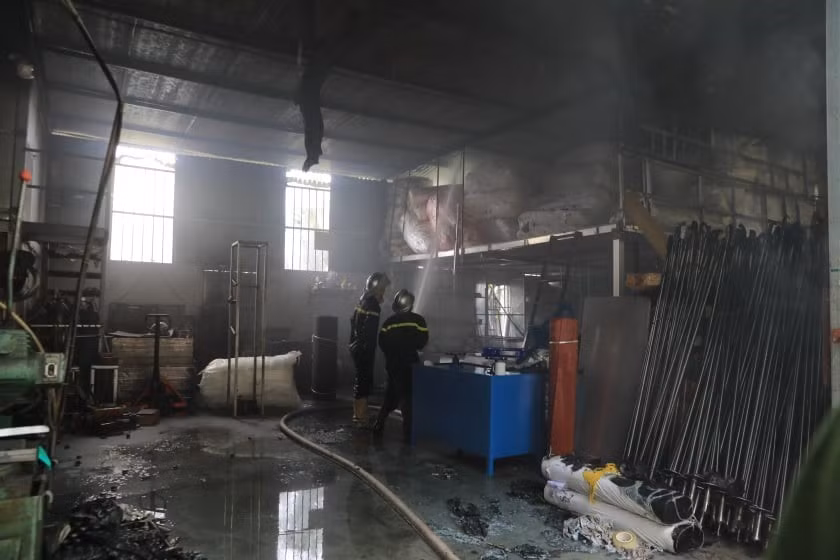 Lực lượng chức năng tiến vào bên trong kho hàng để chữa cháy. (Ảnh: Nhật Anh/TTXVN)