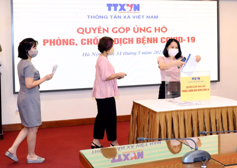 Lãnh đạo, cán bộ, phóng viên, biên tập viên và người lao động của Thông tấn xã Việt Nam tham gia quyên góp, ủng hộ Quỹ phòng, chống dịch COVID-19. (Ảnh: Phạm Kiên/TTXVN)