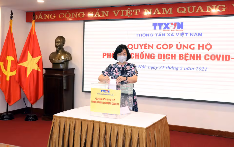  Phó Tổng Giám đốc, Chủ tịch Liên Chi hội Nhà báo TTXVN Vũ Việt Trang quyên góp, ủng hộ Quỹ phòng, chống dịch COVID-19. (Ảnh: Phạm Kiên/TTXVN)