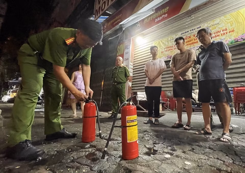 Tổ liên gia số 05, phường Bưởi, quận Tây Hồ (Hà Nội) nghe cán bộ công an hướng dẫn cách sử dụng bình chữa cháy. (Ảnh: Lâm Khánh/TTXVN)