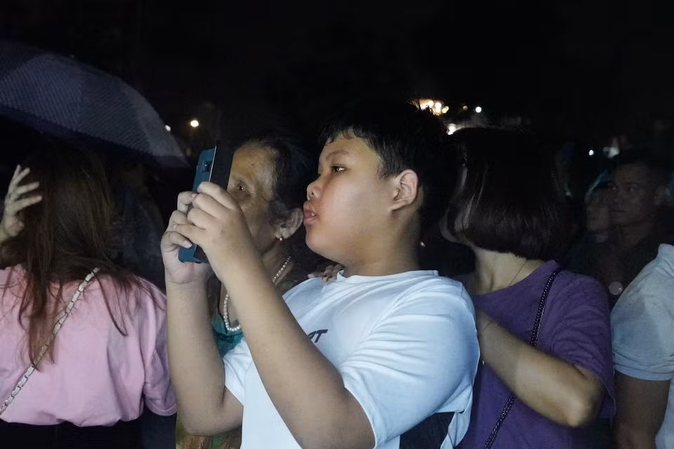 Các em nhỏ cũng bị "hút hồn" trước khung cảnh rực rỡ của buổi bắn pháo hoa. (Ảnh: Việt Anh/Vietnam+)