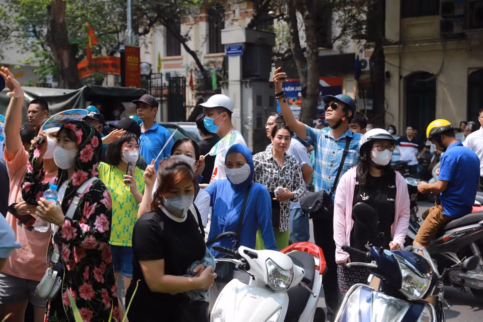 Nhiều bậc phụ huynh 'túc trực' bên ngoài điểm thi để chờ đón con em mình. (Ảnh: PV/Vietnam+)