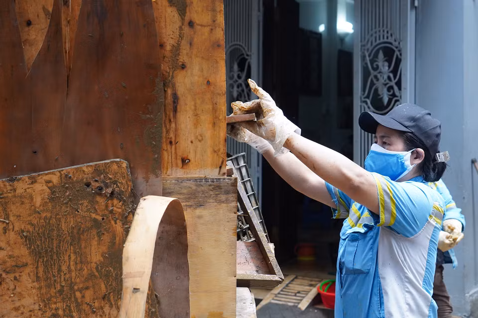 Mỗi người góp một chút sức lực để cảnh quan khu phố sớm khôi phục diện mạo. (Ảnh: Việt Anh/Vietnam+)