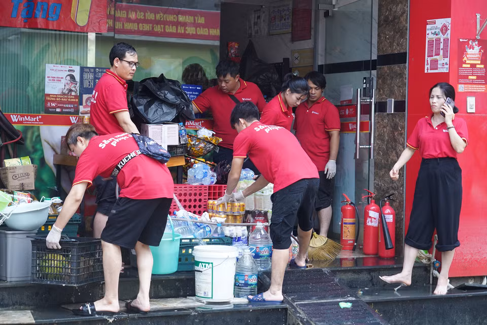 Ngay sau khi nước rút, bà con khu phố đã tất bật bắt tay vào công cuộc dọn dẹp, vệ sinh nhà cửa sau mưa lũ. (Ảnh: Việt Anh/Vietnam+)