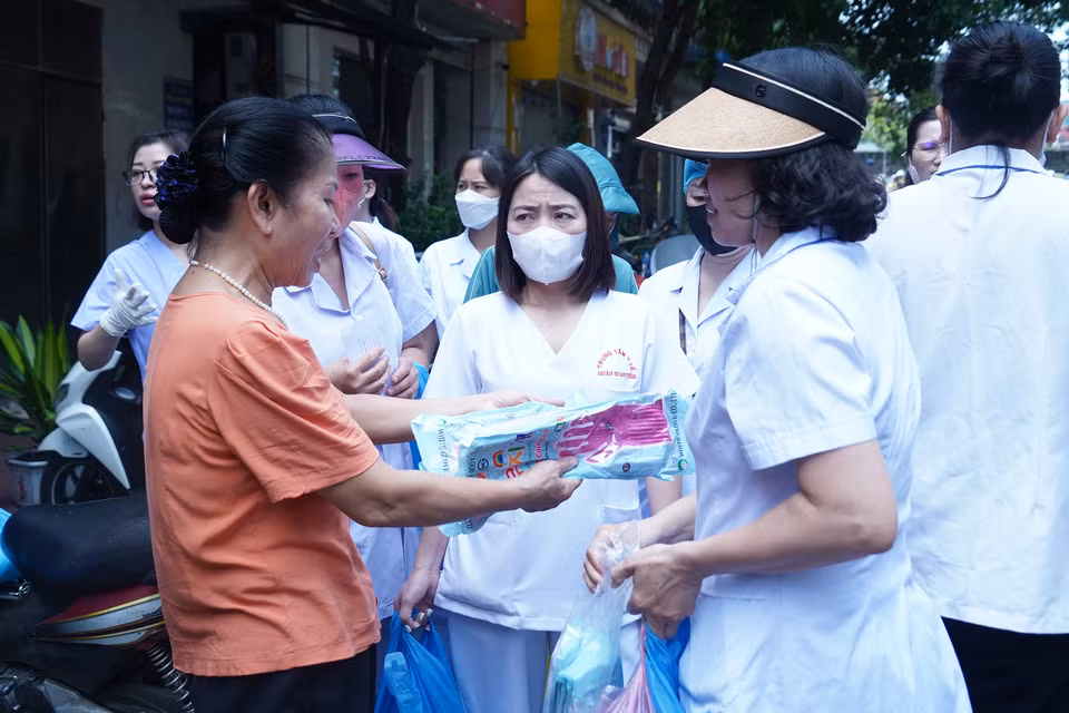 Ủy ban Nhân dân phường Phúc Tân phát găng tay, dung dịch vệ sinh khử khuẩn để người dân khu phố tiến hành dọn dẹp. (Ảnh: Việt Anh/Vietnam+)