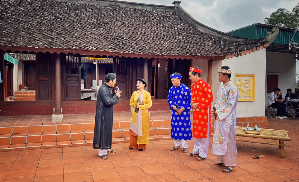 Hoạt cảnh “Ông đồ Nghệ và con cá gỗ” cho thấy tinh thần khổ luyện thành tài của cả cộng đồng làng Quỳnh xưa và nay. (Ảnh: Mai Mai/Vietnam+)