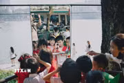 Các em nhỏ vui đùa với chong chóng. (Ảnh: Phạm Tuấn Anh/TTXVN)