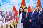 Thủ tướng Lê Minh Hưng và Thủ tướng Cộng hòa Ba Lan Donald Tusk tham quan trưng bày ảnh về quan hệ hợp tác giữa hai nước do Thông tấn xã Việt Nam thực hiện. (Ảnh: Dương Giang/TTXVN)