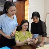 Cán bộ công chức phường Cửa Lò (Nghệ An) cập nhật thông tin trên thiết bị di động. (Ảnh: Bích Huệ/TTXVN)