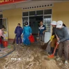 Thầy cô giáo dọn dẹp vệ sinh nhà trường để học sinh sớm được quay lại học tập. (Ảnh: Nguyên Dung/TTXVN)