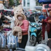 Người lao động, bán hàng trên phố che chắn kỹ chống rét. (Ảnh: Hoàng Hiếu/TTXVN)