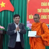 Thứ trưởng Bộ Dân tộc và Tôn giáo Y Thông tặng quà chùa Ta Khvích Thmây (xã Hồ Đắc Kiện). (Ảnh: Trung Kiên/TTXVN)