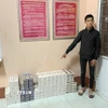 Đối tượng vận chuyển thuốc lá lậu khuya ngày 26/3/2026 bị bắt giữ cùng tang vật. (Ảnh: TTXVN phát)