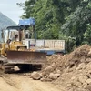 Các đơn vị thi công nỗ lực sửa chữa tuyến đường dẫn vào thôn Phú Hải, Phú Đồng. (Ảnh: Tường Quân/TTXVN)