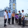 Cán bộ xóm 2, xã Nghĩa Sơn tới nhà thờ trên địa bàn để tuyên truyền, vận động người dân đồng thuận với chủ trương sắp xếp, tổ chức lại thôn, tổ dân phố. (Ảnh: Công Luật/TTXVN)