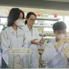 Tiến sỹ Nguyễn Hồ Thùy Linh hướng dẫn sinh viên nghiên cứu trong phòng thí nghiệm. (Ảnh: Thu Hoài/TTXVN)