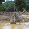 Chân cầu treo Đền Vạn và hệ thống trụ cáp còn sót lại sau trận lũ lịch sử xảy ra vào tối 22 và rạng sáng ngày 23/7/2025. (Ảnh: Xuân Tiến/TTXVN)