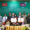 Phó Chủ tịch UBND tỉnh An Giang Lê Trung Hồ (trái) và ngài Khiev Rithiphorn, Phó Tỉnh trưởng tỉnh Kampot ký kết về trao đổi, thống nhất và triển khai Hiệp định Thương mại Biên giới Việt Nam - Campuchia. (Ảnh: TTXVN phát)