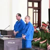 Các bị cáo Đặng Thanh Tuấn và Phạm Văn Tiến nghe Hội đồng xét xử Tòa án nhân dân tỉnh Tây Ninh tuyên án. (Ảnh: TTXVN phát)