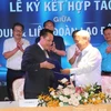 Ông Võ Khắc Thái, Phó Chủ tịch Liên đoàn Lao động TP. Hồ Chí Minh và ông Lê Xuân Lành, Chủ tịch Hội đồng Quản trị Công ty Cổ phần Phát triển Dịch vụ LNT 7979 thực hiện nghi thức ký kết bản ghi nhớ hợp tác xây dựng 30.000 nhà ở xã hội cho công nhân. (Ảnh: Thanh Vũ/TTXVN)