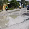 Người và phương tiện vất vả đi qua Quốc lộ 30 đoạn thuộc địa bàn ấp Gò Da, xã Tân Hồng (tỉnh Đồng Tháp). (Ảnh: Nhựt An/TTXVN)