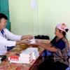 Phát thuốc miễn phí cho nhân dân vùng bị ngập lụt xã Chiềng Khoong, tỉnh Sơn La. (Ảnh: Quang Quyết/TTXVN)