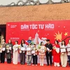 Đại diện Ban tổ chức trao chứng nhận tham gia trưng bày tranh “Dân tộc tự hào” cho các họa sỹ. (Ảnh: Tuyết Mai/TTXVN)