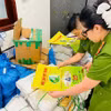 Lực lượng chức năng kiểm tra bao bì giả thương hiệu gạo ST25. (Ảnh: TTXVN)