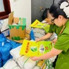 Lực lượng chức năng kiểm tra bao bì giả thương hiệu gạo ST25. (Ảnh: TTXVN)