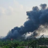 Đám cháy lan rộng và cột khói bốc cao hàng chục mét. (Ảnh: Quốc Lũy/TTXVN)