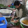 Ông Nguyễn Tất Lớ, làng Thủy Đường, gói bánh. (Ảnh: Tiến Vĩnh/TTXVN)